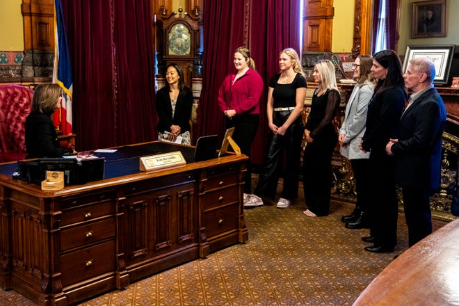 Iowa Gov. Kim Reynolds speaks with Iowa women's wrestling staff and athletes during a proclamation signing declaring April 3 as University of Iowa Women's Wrestling Day in the state of Iowa on Wednesday, April 3, 2024, in Des Moines.