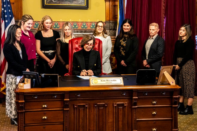 Iowa Gov. Kim Reynolds reads a proclamation declaring April 3 as University of Iowa Women's Wrestling Day, in the state of Iowa, while surrounded by members of the team and staff on Wednesday, April 3, 2024, in Des Moines.