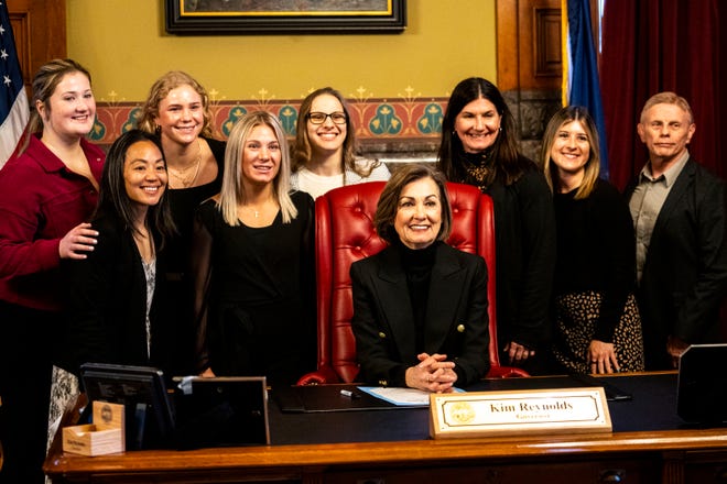 Iowa Gov. Kim Reynolds and Iowa women's wrestling athletes and staff pose for a photo during a proclamation signing declaring April 3 as University of Iowa Women's Wrestling Day in the state of Iowa on Wednesday, April 3, 2024, in Des Moines.