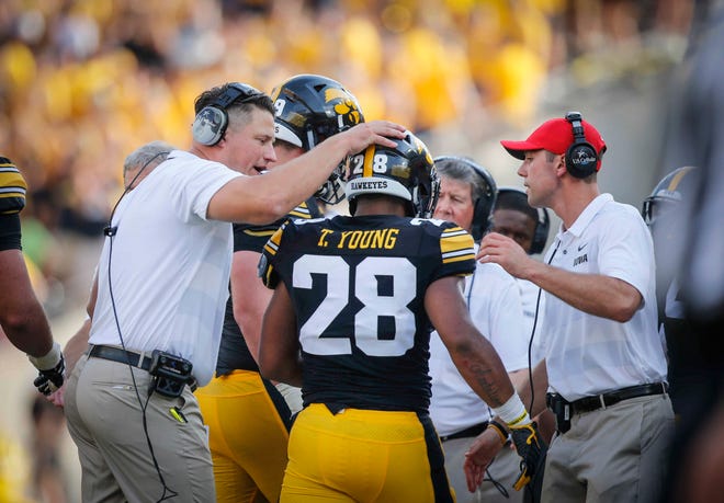 Iowa offensive coordinator Brian Ferentz pats the helmet of running back Toren Young after a big running play against Northern Illinois on Saturday, Sept. 1, 2018, at Kinnick Stadium in Iowa City.