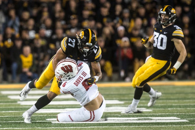 Iowa defensive back Amani Hooker (27) tackles Wisconsin wide receiver Danny Davis III (6) during an NCAA football game on Saturday, Sept. 22, 2018, at Kinnick Stadium in Iowa City.