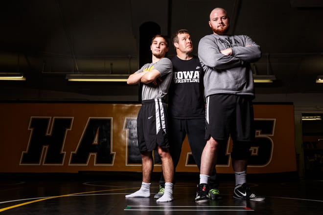 Head coach Tom Brands steps into a photo with Iowa wrestlers Spencer Lee and Sam Stoll during Iowa wrestling media dayMonday, Nov. 5, 2018.