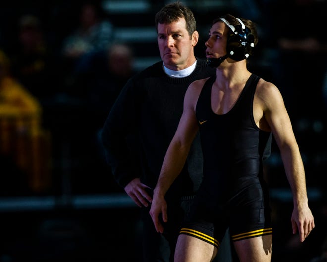 Iowa head coach Tom Brands stands behind Spencer Lee before Lee's match at 125 during an NCAA wrestling dual on Friday, Nov. 16, 2018, at Carver-Hawkeye Arena in Iowa City.