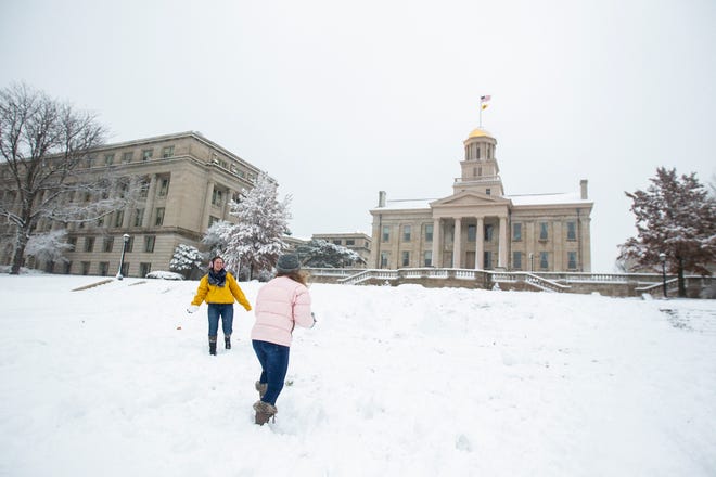 University of Iowa freshman Sarah Nighswonger, left, and Caroline Pickart throw snowballs during a snow storm on Sunday, Nov. 25, 2018, on the west side of the Pentacrest in Iowa City.