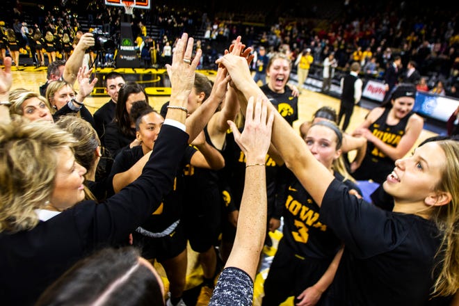 Iowa Hawkeyes players huddle with Iowa head coach Lisa Bluder (bottom left) after defeating the Cyclones a Cy-Hawk series NCAA women's basketball game on Wednesday, Dec. 5, 2018, at Carver-Hawkeye Arena in Iowa City.