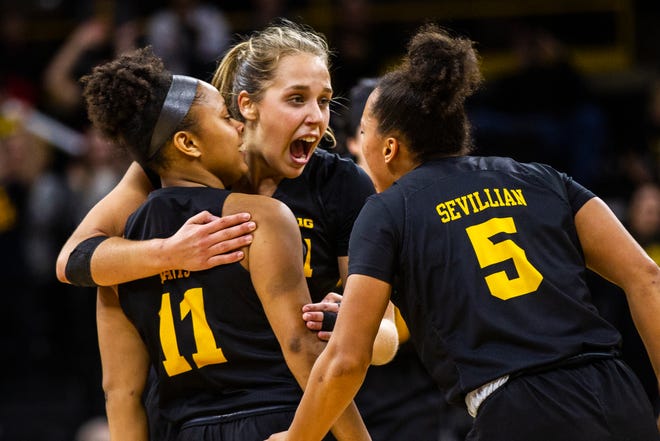 Iowa guard Tania Davis (11) celebrates with Iowa guard Kathleen Doyle (22) and Iowa guard Alexis Sevillian (5) after making a 3-point basket during a Cy-Hawk series NCAA women's basketball game on Wednesday, Dec. 5, 2018, at Carver-Hawkeye Arena in Iowa City.