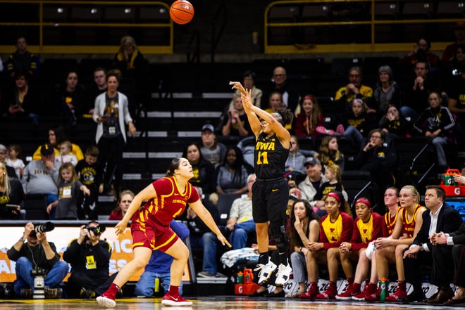 Iowa guard Tania Davis (11) makes a 3-point basket while being defended by Iowa State guard Rae Johnson (4) during a Cy-Hawk series NCAA women's basketball game on Wednesday, Dec. 5, 2018, at Carver-Hawkeye Arena in Iowa City.