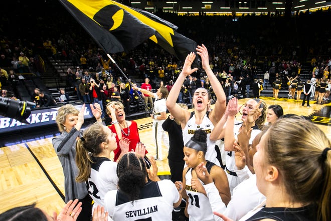 Iowa forward Hannah Stewart (21) claps while celebrating with Hawkeye teammates along with Iowa head coach Lisa Bluder (gray) and associate Jan Jansen (red) during a NCAA Big Ten Conference women's basketball game on Sunday, Jan. 27, 2019, at Carver-Hawkeye Arena in Iowa City, Iowa. The Hawkeyes defeated Purdue, 72-58.