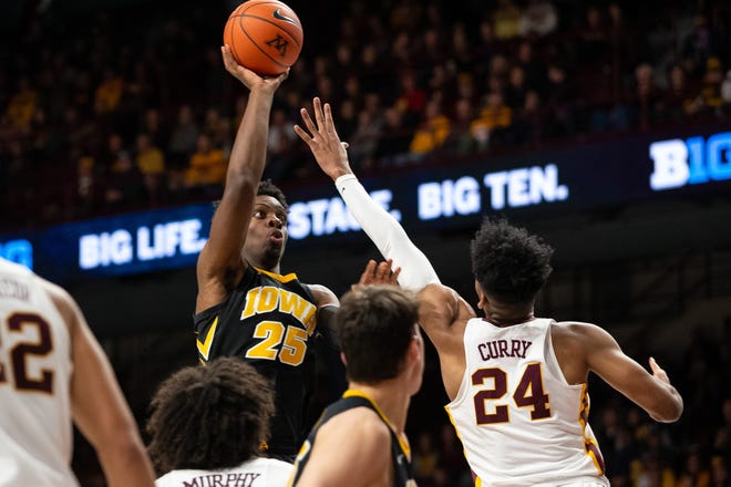 Iowa Hawkeyes forward Tyler Cook (25) shoots the ball over Minnesota Gophers forward Eric Curry (24) during the second half at Williams Arena. Mandatory Credit: Harrison Barden-USA TODAY Sports