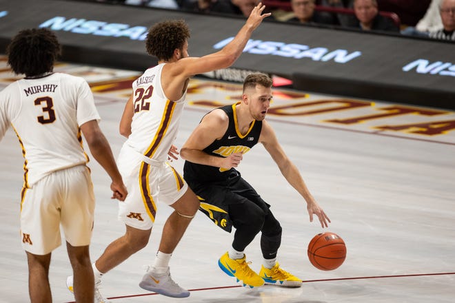 Iowa Hawkeyes guard Jordan Bohannon (3) dribbles the ball as Minnesota Gophers guard Gabe Kalscheur (22) defends during the second half at Williams Arena. Mandatory Credit: Harrison Barden-USA TODAY Sports
