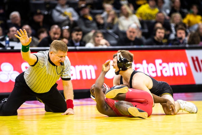 Iowa's Spencer Lee, top, reacts after taking a hand to the face while wrestling Indiana's Elijah Oliver at 125 during a NCAA Big Ten Conference wrestling dual on Friday, Feb. 15, 2019 at Carver-Hawkeye Arena in Iowa City, Iowa.