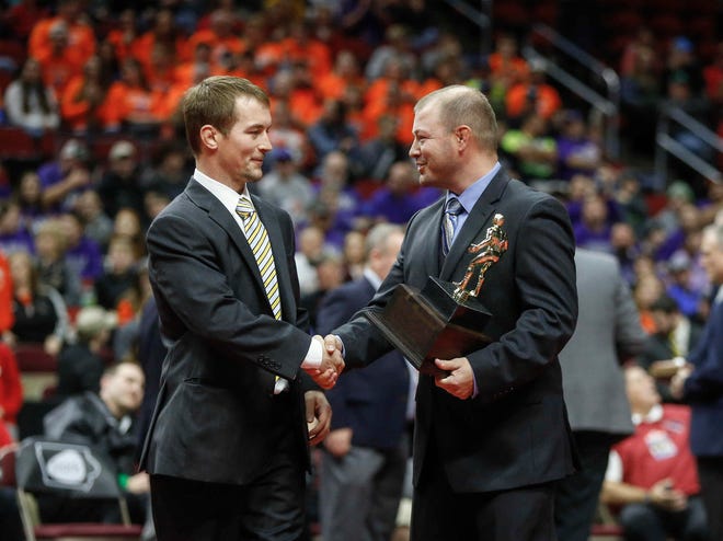 Emmetsburg head wrestling coach Tyler Bjustrom, left, is presented with the Class 1A wrestling coach of the year prior to the start of the state championship wrestling finals on Saturday, Feb. 16, 2019, at Wells Fargo Arena in Des Moines.