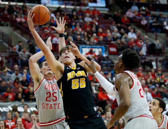 Iowa forward Luka Garza, center, goes up for a shot between Ohio State forward Kyle Young, left, and forward Andre Wesson during the first half of an NCAA college basketball game in Columbus, Ohio, Tuesday, Feb. 26, 2019.