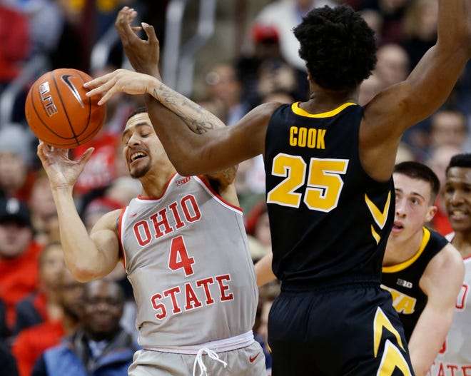 Ohio State guard Duane Washington, left, works for a loose ball against Iowa forward Tyler Cook during the second half of an NCAA college basketball game in Columbus, Ohio, Tuesday, Feb. 26, 2019. Ohio State won 90-70.