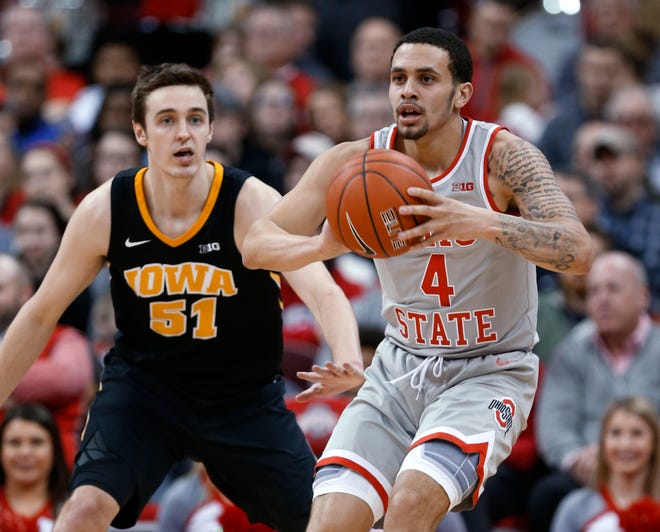 Ohio State guard Duane Washington, right, passes the ball away from Iowa forward Nicholas Baer during the first half of an NCAA college basketball game in Columbus, Ohio, Tuesday, Feb. 26, 2019.