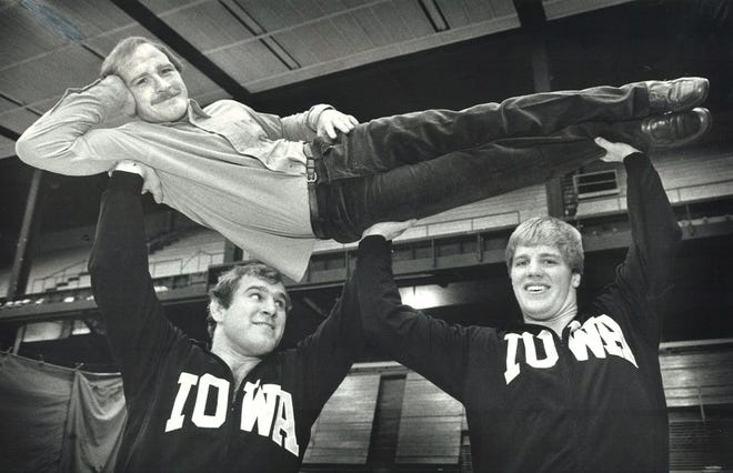 From 1982: Hawkeyes wrestlers Ed Banach, left, and Pete Bush lift Iowa coach Dan Gable.