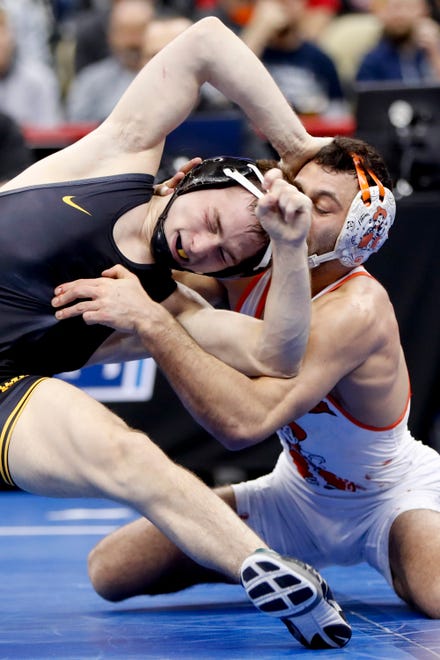 Iowa's Spencer Lee, left, grapples with Oklahoma State's Nicholas Piccinni during their 125-pound match in the semifinals of the NCAA wrestling championships, Friday, March 22, 2019, in Pittsburgh. Lee won and advances to face Virginia's Jack Mueller in the championship Saturday.