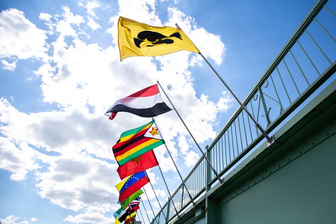 Flags wave in the wind off of the Iowa Memorial Union bridge over the Iowa River as part of the "Bridging Our World" display during the last day of finals week, Friday, May 10, 2019, on the University of Iowa campus in Iowa City, Iowa.