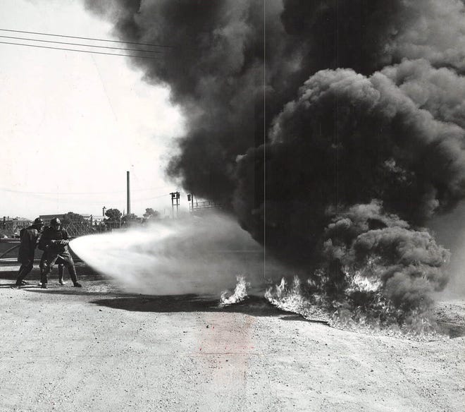 From 1953: Des Moines firemen test special fog-producing nozzles at the Pioneer ballpark parking lot. Fifth-five gallons of highly flammable lacquer thinner was poured over the ground and ignited. District fire chief Robert Burns, who directed the experiment, instructed the men to "cool off" the top of the fire with the spray, then move in and snuff out the flames.