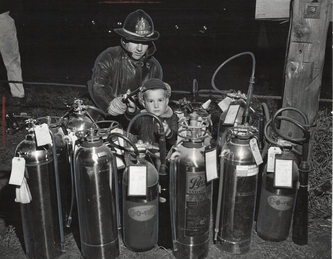 From 1957: Des Moines fireman Richard Stradley of Station 1 shows 4-year-old Thomas Dusenberry how to use a fire extinguisher during a demonstration at Pioneer Park.