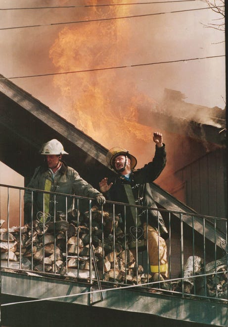 From 1987: Des Moines District Fire Chief Lanny Williams, left, and firefighter Carl Linder call for water as flames shoot into the sky at a fire on Grand Avenue.