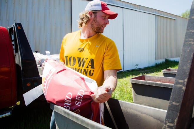 With his dad helping him, former Iowa Hawkeye football star Drew Ott refills the bins on his planter while planting corn on Thursday, May 16, 2019, in Trumbull, NE. Ott was a standout defensive end with a good chance of playing in the NFL before a series of injuries cut his career short.