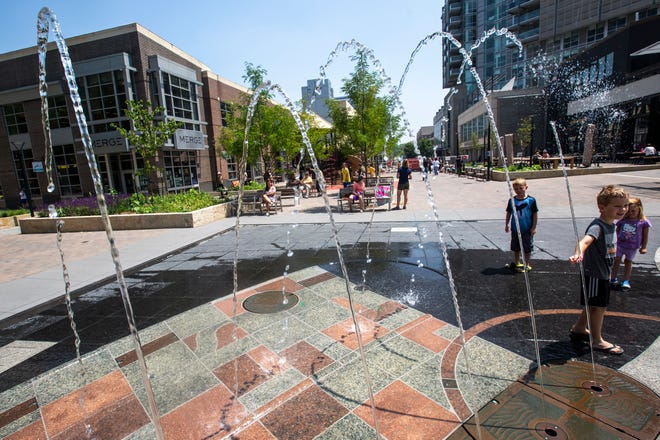 Viggo Brakke, 5, of Iowa City, interrupts the flow of water while playing with Will Ooms, 6, and his sister Morgan, 3, Monday, July 8, 2019, at the Weatherdance fountain in the Pedestrian Mall at the intersections of Dubuque and College Streets in downtown Iowa City, Iowa. The two families came to the ped mall Monday afternoon to visit the library and play in the recently reopened fountain.