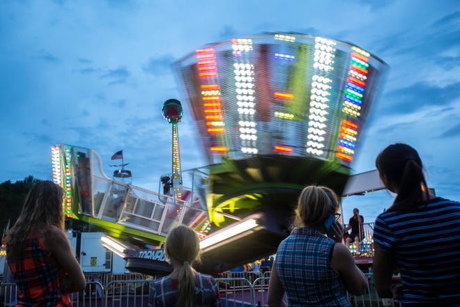 People watch as the "Tornado" carnival ride spins during the 90th annual Johnson County Fair, Sunday, July 21, 2019, the Johnson County Fairgrounds in Iowa City, Iowa.