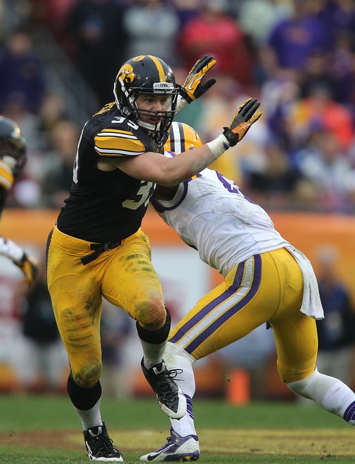 Iowa linebacker Travis Perry gets by a member of LSU's offense in the Outback Bowl on Jan. 1, 2014, in Tampa, Florida.