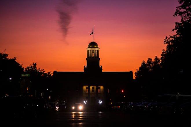 An orange and pink sky is illuminated as the sun sets behind the Old Capitol building, Monday, Aug. 19, 2019, on the University of Iowa campus in Iowa City, Iowa.