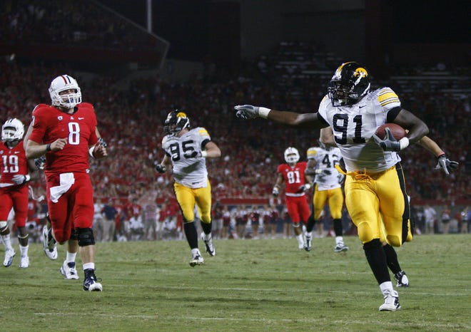 Arizona's Nick Foles looks on as Iowa's Broderick Binns takes an interception for a touchdown in the 4th quarter during their NCAA football game Saturday, Sept. 18, 2010 in Tucson.