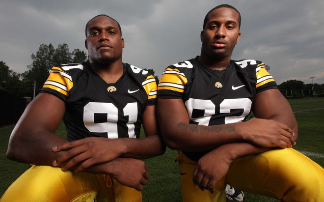 University of Iowa football players, defensive linemen (91) Broderick Binns, left, and (93) Mike Daniels pose for photos during the annual Iowa football media day Friday, Aug. 5, 2011, in Iowa City.