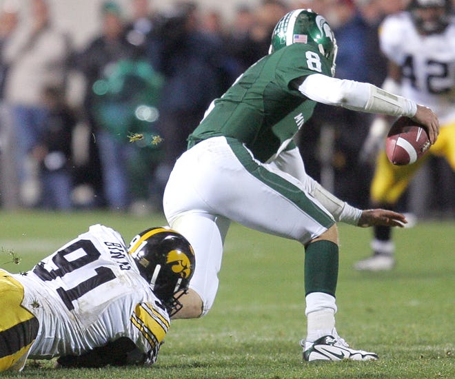 Iowa defender Broderick Binns, left, gets a hold of the leg of Michigan State quarterback Kirk Cousins during the fourth quarter of their game Saturday, Oct. 24, 2009, at Spartan Stadium in East Lansing, Mich. Iowa won the game 15-13.