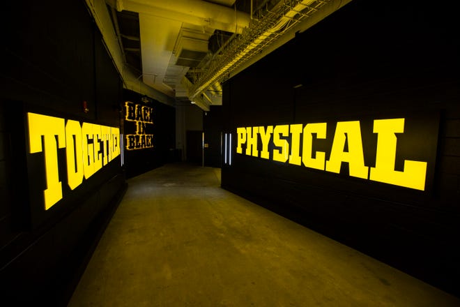 Yellow letters spell out the words "Together," "Back in Black," and "Physical" in the tunnel that leads down towards the field during a behind the scenes tour, Friday, Aug. 23, 2019, at Kinnick Stadium in Iowa City, Iowa.