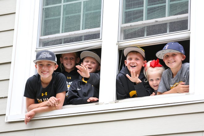 Young fans waive from a window on Melrose Court before the Iowa football game against Miami of Ohio in Iowa City on Sat., Aug. 31, 2019.
