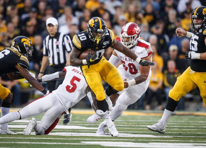 Iowa junior running back Mekhi Sargent is tripped up by Miami of Ohio (and former Hawkeye) cornerback Manny Rugamba in the first quarter at Kinnick Stadium in Iowa City on Saturday, Aug. 31, 2019.
