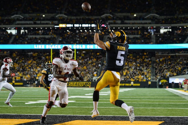 Aug 31, 2019; Iowa City, IA, USA; Iowa Hawkeyes wide receiver Oliver Martin (5) catches a touchdown pass from quarterback Nate Stanley (not shown) over Miami (Oh) Redhawks defensive back Zedrick Raymond (14) during the third quarter at Kinnick Stadium. Mandatory Credit: Jeffrey Becker-USA TODAY Sports