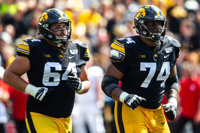 Iowa offensive lineman Kyler Schott (64) and Tristan Wirfs (74) run to the sideline during a NCAA Big Ten Conference football game against Rutgers, Saturday, Sept. 7, 2019, at Kinnick Stadium in Iowa City, Iowa.