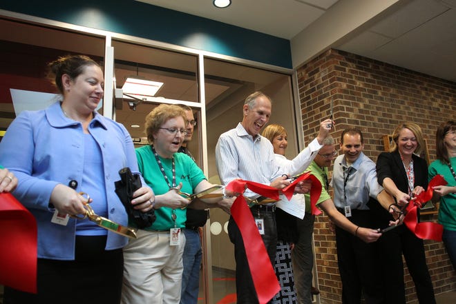 ACT President Jon Erickson (center) cuts a ceremonial ribbon during the grand opening of ACT's wellness center on Tuesday, May 26, 2015. Construction for the 8,000-square-foot facility began last Labor Day. Amenities include a cardio and weight room, showers, ping pong, foosball, TV lounge and a cafe. Employees will be able to use the facility before, during and after work, seven days a week.