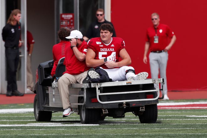Indiana Hoosiers offensive lineman Coy Cronk (54) is carted off the field with a leg injury in a game against the Connecticut Huskies during the first quarter at Memorial Stadium .