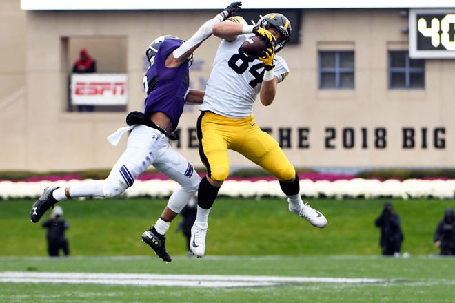 Iowa tight end Sam LaPorta, right, catches a pass as Northwestern defensive back Greg Newsome II, left, defends him during the first half of an NCAA college football game, Saturday, Oct. 26, 2019, in Evanston, Ill. (AP Photo/David Banks)