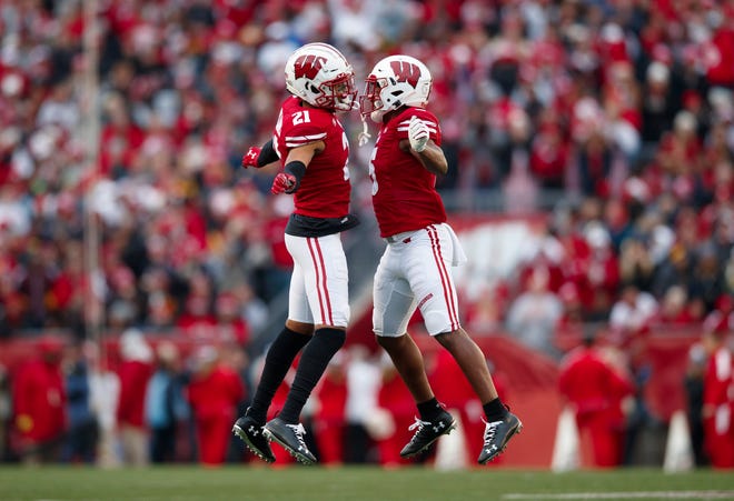 Nov 9, 2019; Madison, WI, USA; Wisconsin Badgers cornerback Caesar Williams (21) and cornerback Rachad Wildgoose (5) celebrate following a turnover against the Iowa Hawkeyes during the second quarter at Camp Randall Stadium.