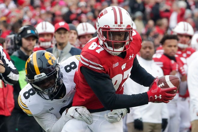 Wisconsin's Quintez Cephus catches a pass in front of Iowa's Matt Hankins during the first half of an NCAA college football game Saturday, Nov. 9, 2019, in Madison, Wis. (AP Photo/Morry Gash)