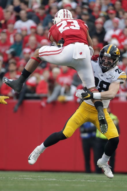 Wisconsin's Jonathan Taylor tries to leap over Iowa's Jack Koerner during the first half of an NCAA college football game Saturday, Nov. 9, 2019, in Madison, Wis. (AP Photo/Morry Gash)