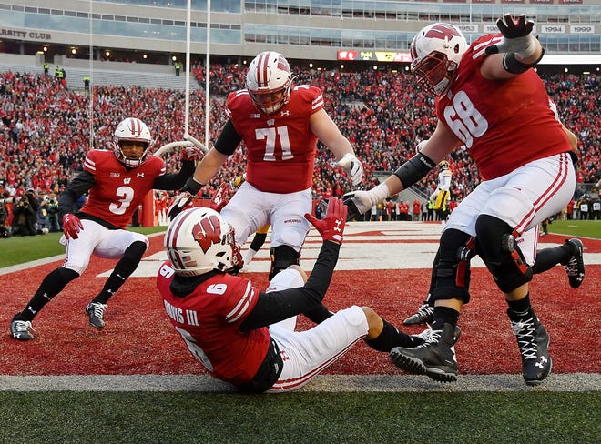 MADISON, WISCONSIN - NOVEMBER 09: Danny Davis III #6 of the Wisconsin Badgers celebrates with Kendric Pryor #3, Cole Van Lanen #71 and David Moorman #68 of the Wisconsin Badgers after scoring a touchdown in the first half against the Iowa Hawkeyes at Camp Randall Stadium on November 09, 2019 in Madison, Wisconsin. (Photo by Quinn Harris/Getty Images)
