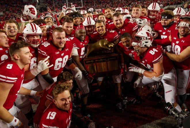 Nov 9, 2019; Madison, WI, USA; Wisconsin Badgers players celebrate with the Heartland Trophy following the game against the Iowa Hawkeyes at Camp Randall Stadium. Mandatory Credit: Jeff Hanisch-USA TODAY Sports