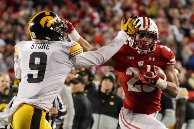 Wisconsin's Jonathan Taylor tries to get past Iowa's Geno Stone during the second half of an NCAA college football game Saturday, Nov. 9, 2019, in Madison, Wis. Wisconsin won 24-22. (AP Photo/Morry Gash)