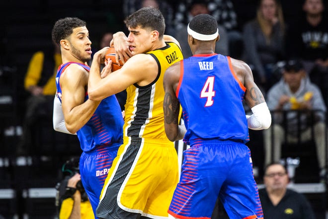 Iowa center Luka Garza (55) battles DePaul's Jaylen Butz, left, and Paul Reed during a NCAA non-conference men's basketball game, Monday, Nov., 11, 2019, at Carver-Hawkeye Arena in Iowa City, Iowa.