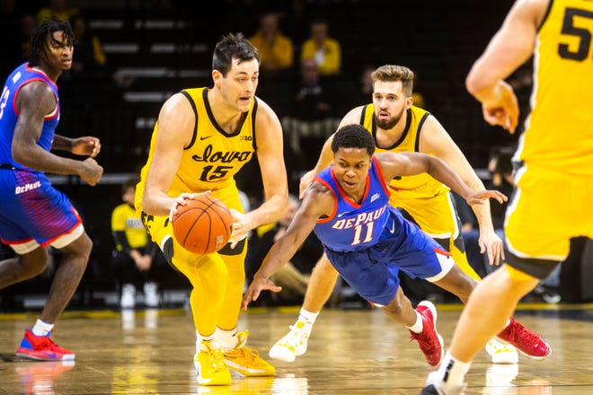 Iowa forward Ryan Kriener (15) attempts to steal a ball away from DePaul's Charlie Moore (11) as Iowa guard Jordan Bohannon (3) defends during a NCAA non-conference men's basketball game, Monday, Nov., 11, 2019, at Carver-Hawkeye Arena in Iowa City, Iowa.