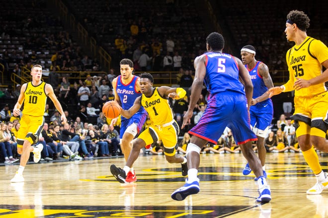 Iowa guard Joe Toussaint (1) takes the ball up court past DePaul's Jaylen Butz (2) during a NCAA non-conference men's basketball game, Monday, Nov., 11, 2019, at Carver-Hawkeye Arena in Iowa City, Iowa.